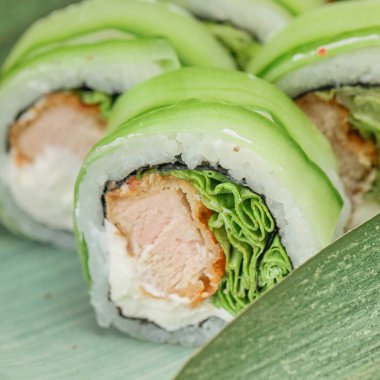 Bir tabağa yerleştirilmiş suşi rulosunun detaylı bir görüntüsü içeriğini ve sunumunu gösteriyor..