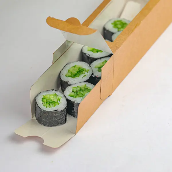 Close-up of a cardboard box filled with assorted sushi rolls.