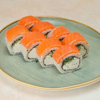 Çeşitli suşi ruloları, nigiri ve sashimi çeşitleri kırsal ahşap bir masada sergilenir..