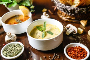 Çeşitli türde çorba ve dilimlenmiş mantarlarla dolu bir masa..