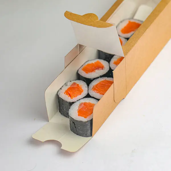 A cardboard box filled with a variety of sushi rolls, neatly arranged and ready to be enjoyed.