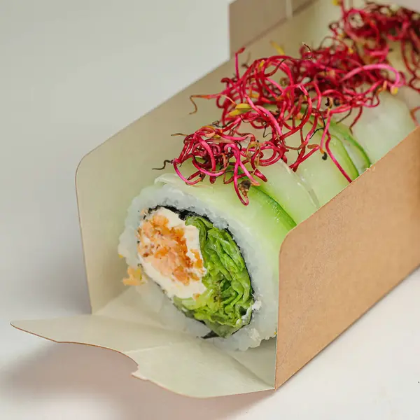A sushi box with a slice of fresh salmon sushi neatly arranged inside.