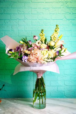 Vazodaki renkli çiçeklerin çarpıcı bir düzeni, parlak renkleriyle masayı aydınlatıyor..