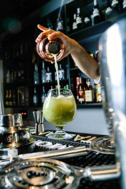 Birisi portakal suyunu bardaktan bardağa boşaltıp taze meyve suyunun akışını yakalıyor..