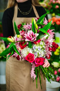 Bir kadın elinde güzel bir buket çiçek tutuyor, fotokopi alanı olan boş bir arkaplana karşı..