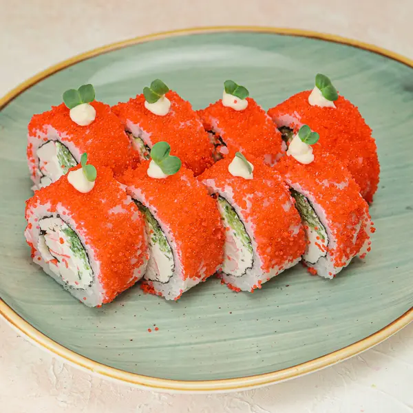 A plate filled with assorted sushi rolls placed on a wooden table.