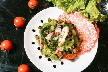 Taze yeşil marulla kaplı salatayla dolu beyaz bir tabak..