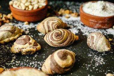 Farklı şekillerde, boyutlarda ve tatlarda çeşitli lezzetli hamur işleriyle dolu bir masa..