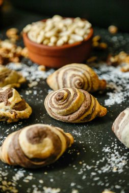 Kruvasanlar, kekler ve çörekler de dahil olmak üzere çeşitli hamur işleri bir masaya güzelce yerleştirilmiştir..