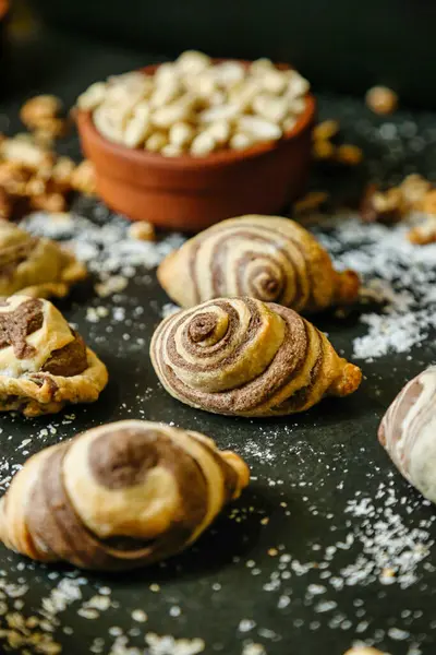 Kruvasanlar, kekler ve çörekler de dahil olmak üzere çeşitli hamur işleri bir masaya güzelce yerleştirilmiştir..