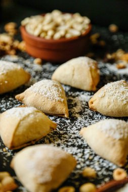 Bir masa çeşitli hamur işleriyle doludur, her biri nazik bir pudra şekerle kaplıdır..