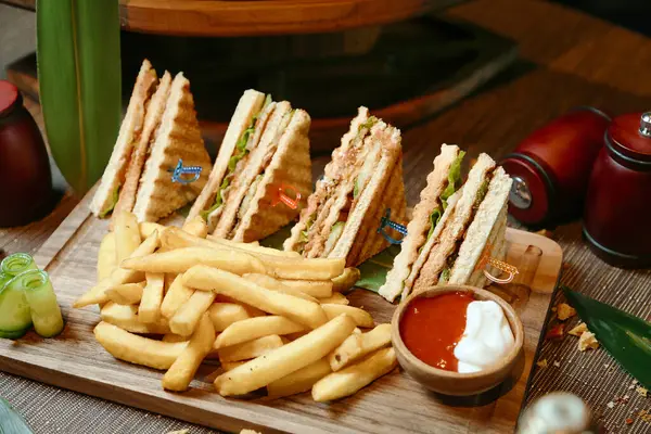 Tagliere Legno Con Taglio Metà Sandwich Accanto Una Porzione Patatine — Foto Stock