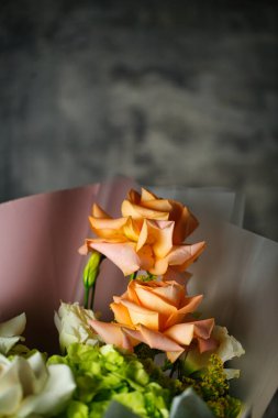 Geniş bir kopya alanı olan bir masanın üzerinde canlı bir çiçek buketi..