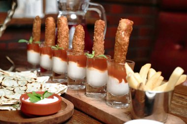 Çeşitli lezzetli yiyeceklerle dolu birkaç bardak bulunan ahşap bir masa..