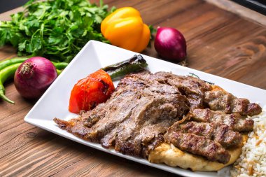 Lezzetli bir et ve pirinç kombinasyonu sunan beyaz bir tabak.