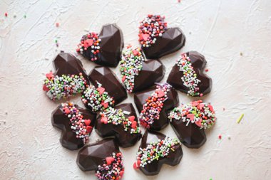 Renkli süslerle süslenmiş çeşitli çikolatalar. Baştan çıkarıcı bir şekilde sergilenmiş..