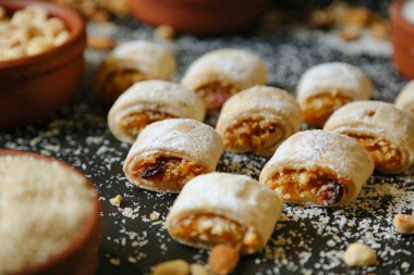 Çeşitli hamur işleriyle dolu bir masa, hepsi bol miktarda pudra şekeriyle kaplanmış..