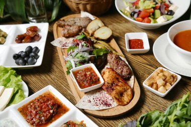 Ahşap bir masa ağız sulandırıcı tabaklarla süslenir, güzelce sunulur ve tadını çıkarmaya hazırdır..