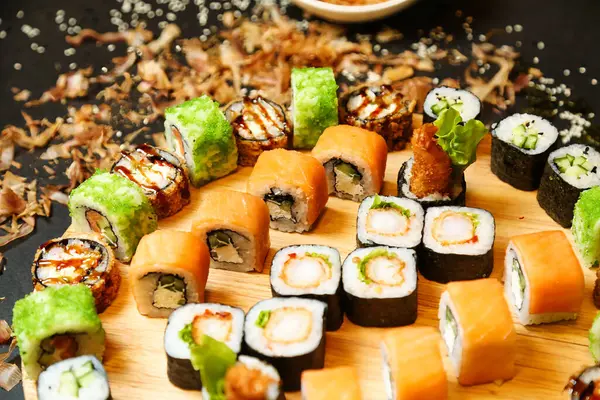 Tahta panoda taze yapılmış suşi, nigiri ve sashimi çeşitleri sergileniyor..