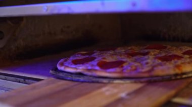 Köy ahşap kesim tahtasının üzerinde duran taze pişmiş bir pizza..