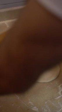 Bir kişi kasenin içinde hamur yoğururken görülüyor..