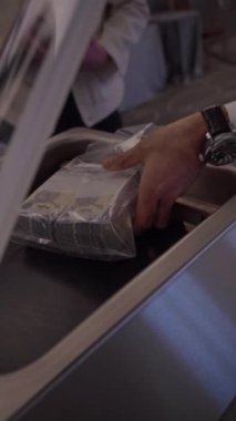 Para birimiyle dolu şeffaf bir plastik poşetin detaylı bir görüntüsü, öncelikle kağıt banknotlar, bir ışık kaynağı tarafından aydınlatılmış..