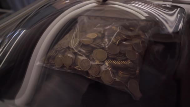 一个装满了很多硬币的袋子放在桌子上 上面放满了钞票 — 图库视频影像