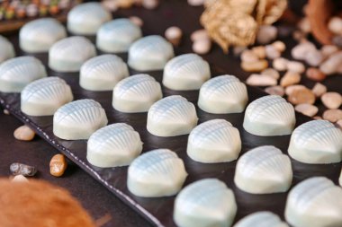 Masaya yerleştirilmiş çeşitli çikolatalarla dolu bir tepsinin ayrıntılı görünümü.