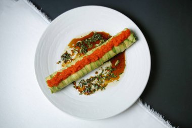 Beyaz bir tabağın yakın plan fotoğrafı. Canlı bir salata, çeşitli sebzeler ve bol miktarda salata sergileniyor..