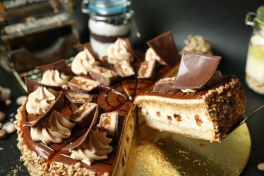 Yeni pişmiş, üçgen dilimli bir pasta. Karmaşık katmanlar ve zengin kremalar sergiliyor..