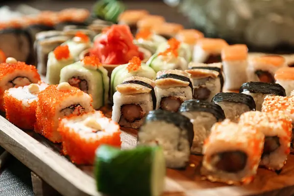 A platter filled with a variety of sushi rolls and nigiri is presented on a table.