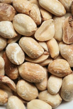 Çeşit çeşit fındıkla dolu beyaz bir kase ahşap bir masanın üzerinde oturur..