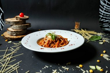 Domates sosuyla kaplanmış ve rendelenmiş parmesan peynirle kaplanmış lezzetli bir spagetti tabağı..