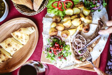Pizza, salata, suşi, meyve, peynir ve tatlı gibi çeşitli yiyeceklerle dolu bir masa..