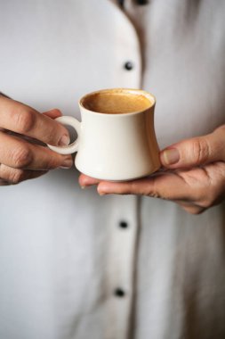 Bir kadın elinde bir fincan kahve tutuyor..