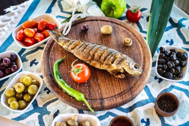 Farklı çeşit yiyeceklerle dolu ahşap bir tabakta lezzetli ve çeşitli çeşitlilikte sergileniyor..