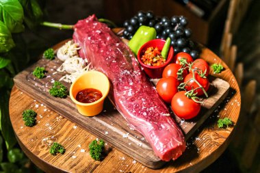 Dayanıklı ahşap bir kesme tahtasının üzerinde hazır bir et parçası..