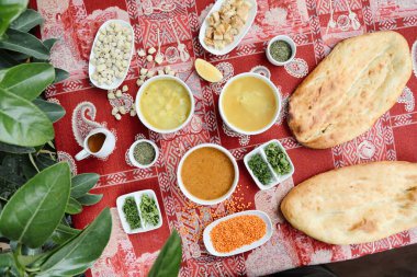 Farklı yemek çeşitleri içeren çeşitli kaselerle dolu bir masa, çeşitli lezzet ve seçenekler sunuyor..