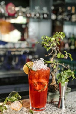 Saksı bitkisinin yanına konmuş ferahlatıcı bir içecekle dolu uzun bir bardak..