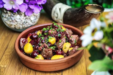 Sağlam ahşap bir masanın üstüne yerleştirilmiş basit ama iştah açıcı bir yemek kasesi..