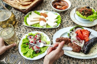 Lezzetli yemekler ve çeşitli içeceklerle dolu tabaklar ile süslenmiş bir masa..