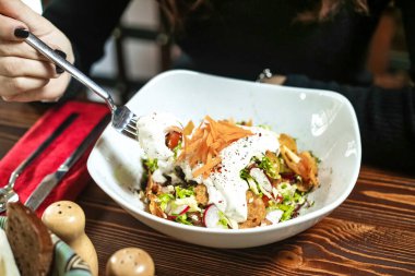 Lezzetli makarna dolu bir kase ve kullanılmaya hazır gümüş çatal..