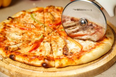 Çeşitli malzemelerle lezzetli bir pizza kırsal bir ahşap kesme tahtasının üzerinde oturup tadını çıkarmaya hazır..