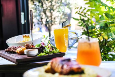 Çeşitli yemeklerden oluşan ağız sulandırıcı bir tabak, yanında da bir bardak taze sıkılmış portakal suyu..