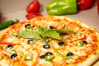 Tahta kesme tahtasının üstünde yeni pişmiş bir pizza..