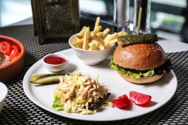 Beyaz tabakta bir sandviç ve patates kızartması var. Tadını çıkarmaya hazır..