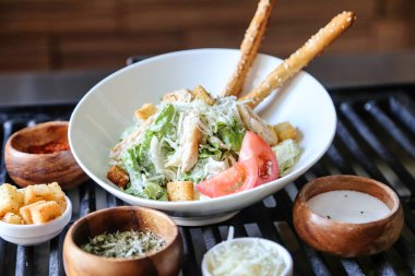 Bir kase salata ve ızgarada ızgara sosu..