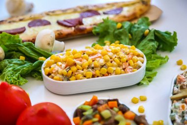 Farklı yemek çeşitlerini gösteren, çeşitli lezzetleri ve mutfak seçeneklerini gösteren bir masa..