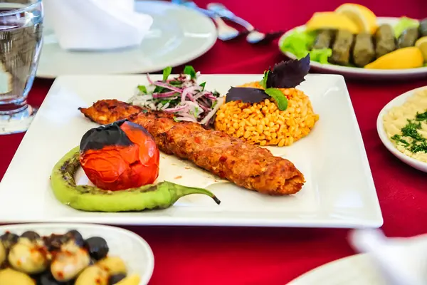 Lezzetli bir tabak yemek ve tabakla dolu kırmızı bir masa..