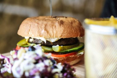 Turşulu, biberli, soğanlı ve yanında lahana salatasıyla servis edilen lezzetli bir hamburger..